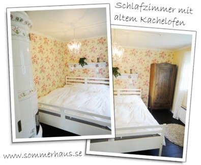Das Schlafzimmer mit Kachelofen des roten Ferienhauses in Schweden am See